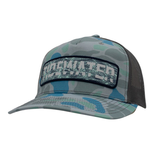 A blue and green camo baseball cap with a grey mesh back and a light green and blue patch on the front containing the tidewater logo.