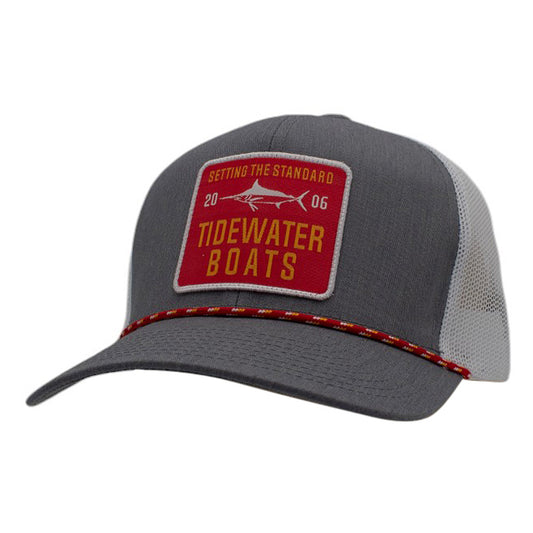 A gray and white trucker hat with a red Tidewater Boats patch and red rope across the bill.