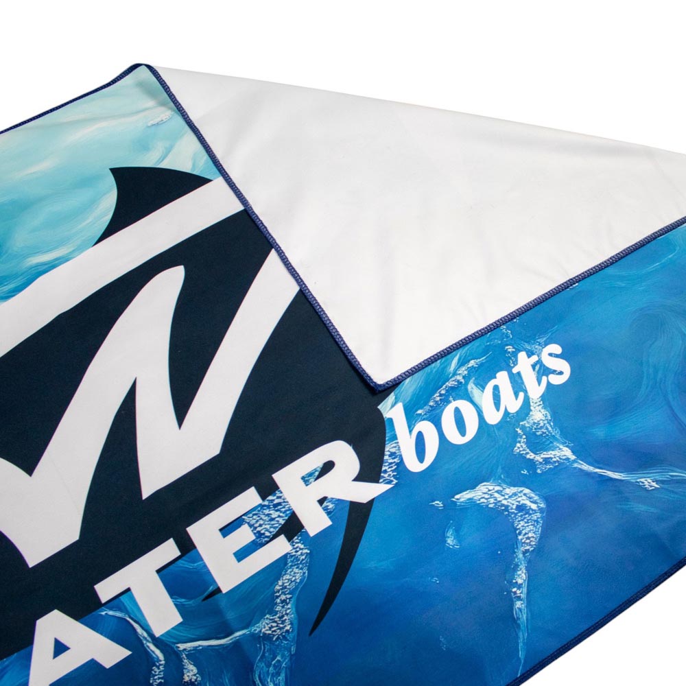 Close-up of a microfiber beach towel with tidewater branding on front and white back.